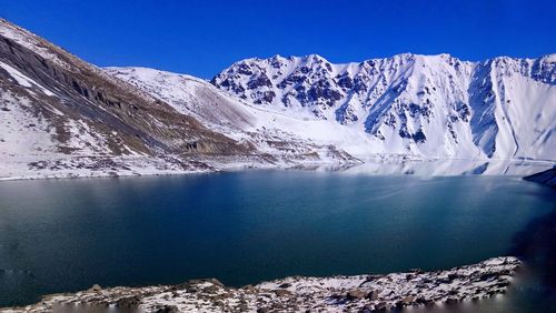 Scenic view of snowcapped mountains against clear blue sky