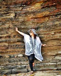 Full length of woman standing against brick wall