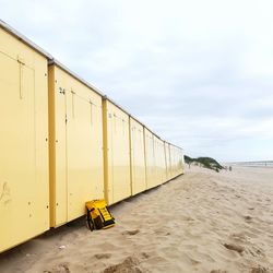 Yellow umbrella on beach against sky