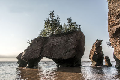 Rock formation in sea against sky