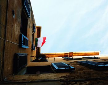 Low angle view of an italian flag shown on a building against sky