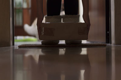 Woman with slippers gets package delivery on door entrance