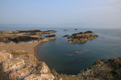 Scenic view of rocks in sea against sky