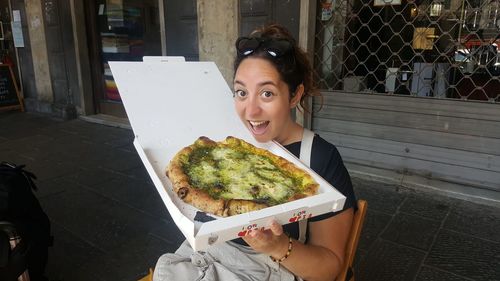 Portrait of smiling woman having pizza in restaurant