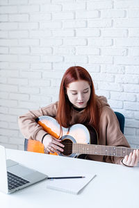 Portrait of young woman using laptop at home