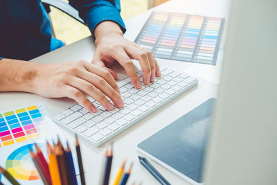 Midsection of man using laptop on table