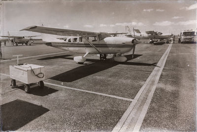 Airplane on airport runway against sky