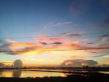 Scenic view of silhouette shore against sky during sunset