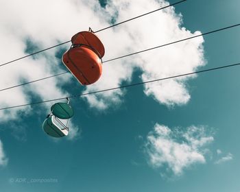 Low angle view of overhead cable car against sky