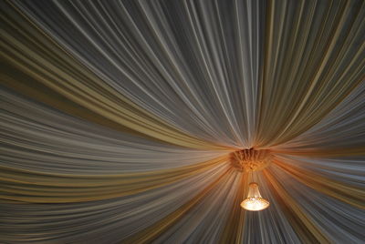 Illuminated chandelier hanging from curtain