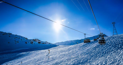 Scenic view of snow covered mountains against blue sky