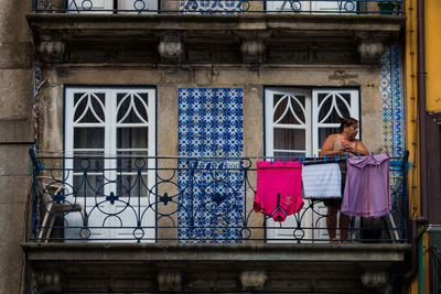 Woman with umbrella against building