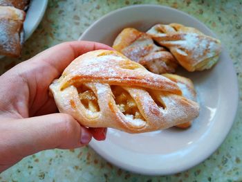 Cropped hand holding baked pastry item