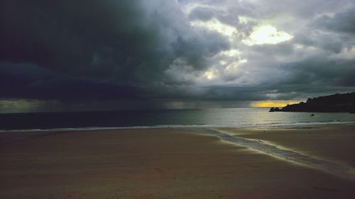 Scenic view of sea against storm clouds