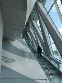 Rear view of man walking on staircase