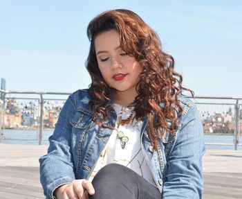 Beautiful young woman against clear sky