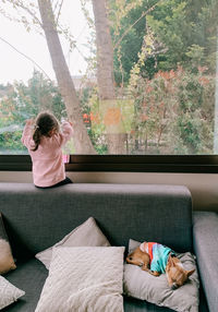 Full length of woman relaxing on sofa