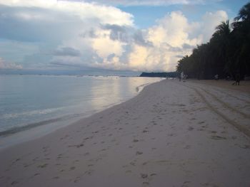 Scenic view of beach against cloudy sky