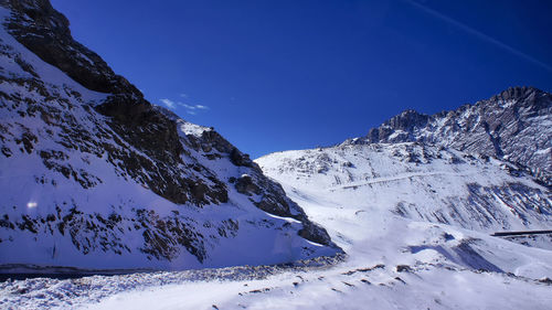 Snow covered mountains against blue sky