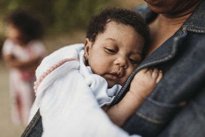 Close up of newborn baby girl laying on mother's chest