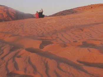 People standing on sand dune in desert
