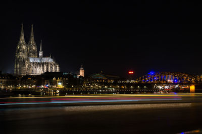 Light trails on road against sky in city at night