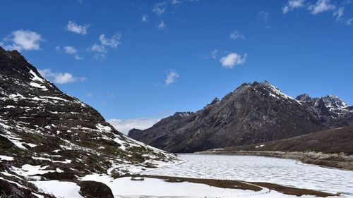 Scenic view of mountains against blue sky during winter