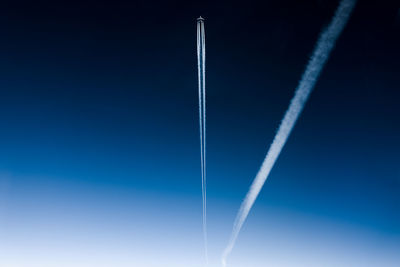 Low angle view of vapor trail against blue sky