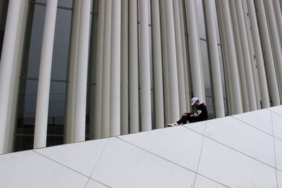 Man photographing against white wall