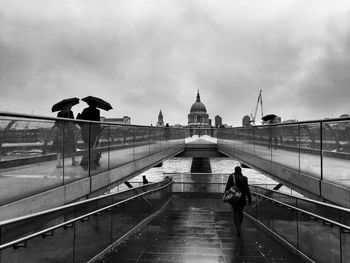 Man walking on bridge in city