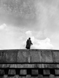 Low angle view of man standing against wall