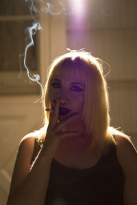 Portrait of young woman smoking cigarette