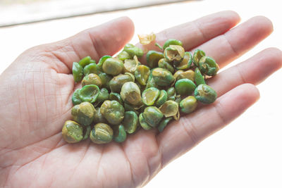 Close-up of hand holding green tomato