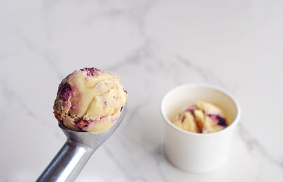 Close-up of ice cream on scoop over table