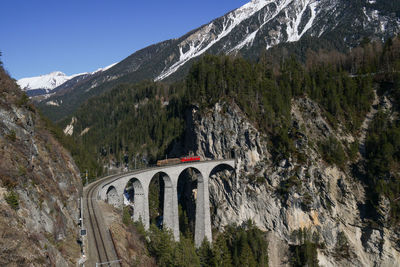 Arch bridge on mountain against sky