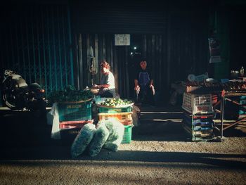 Sellers sitting at market stall in city