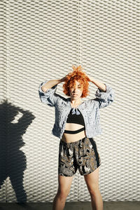 Young alternative redhead girl posing in a metal wall