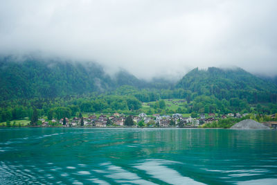 Scenic view of lake by mountains against sky