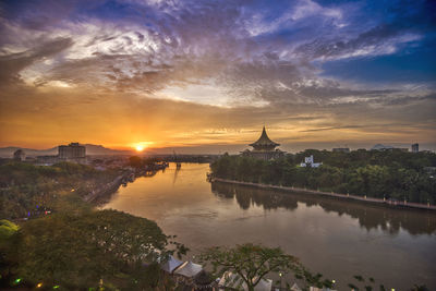 View of buildings at waterfront during sunset