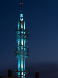 Illuminated building against blue sky at night