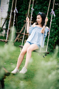 Girl sitting on swing at playground