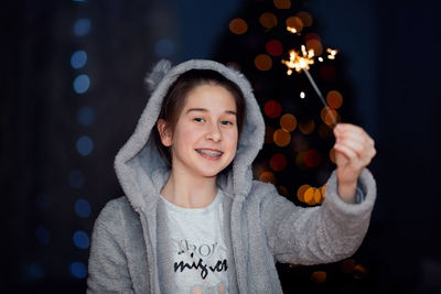 Portrait of young woman holding christmas tree