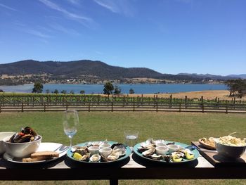 High angle view of breakfast on table by lake against sky