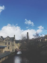 Bridge over river amidst buildings against sky