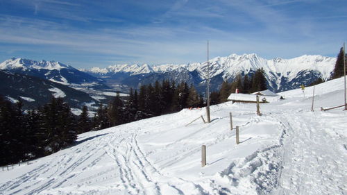 Snow covered land and mountains against sky