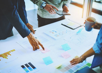 Midsection of business colleagues working on table