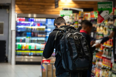 Rear view of man standing at store