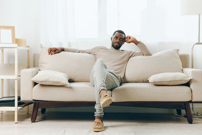 Young woman sitting on sofa at home