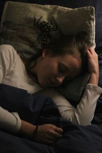 Boy sleeping on bed at home