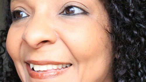 Close-up of smiling woman with curly hair